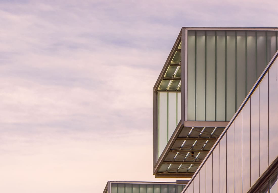 Glassfasade på moderne norsk kontorbygg i solnedgang